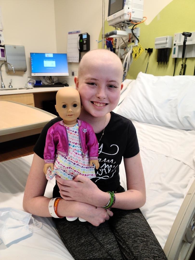 MAKING EVERYONE GLIMMER AND SHIMMER: Emily Hanks being treated at Boston Children's Hospital holds her very special friend. (Photo courtesy of the Glimmer of Hope Foundation)